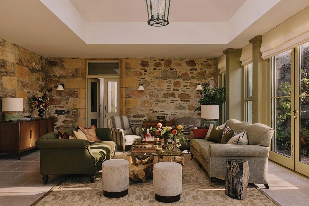 The Orangery at Glenrothes Estate features a stone wall with green couches and elegant pendant lighting