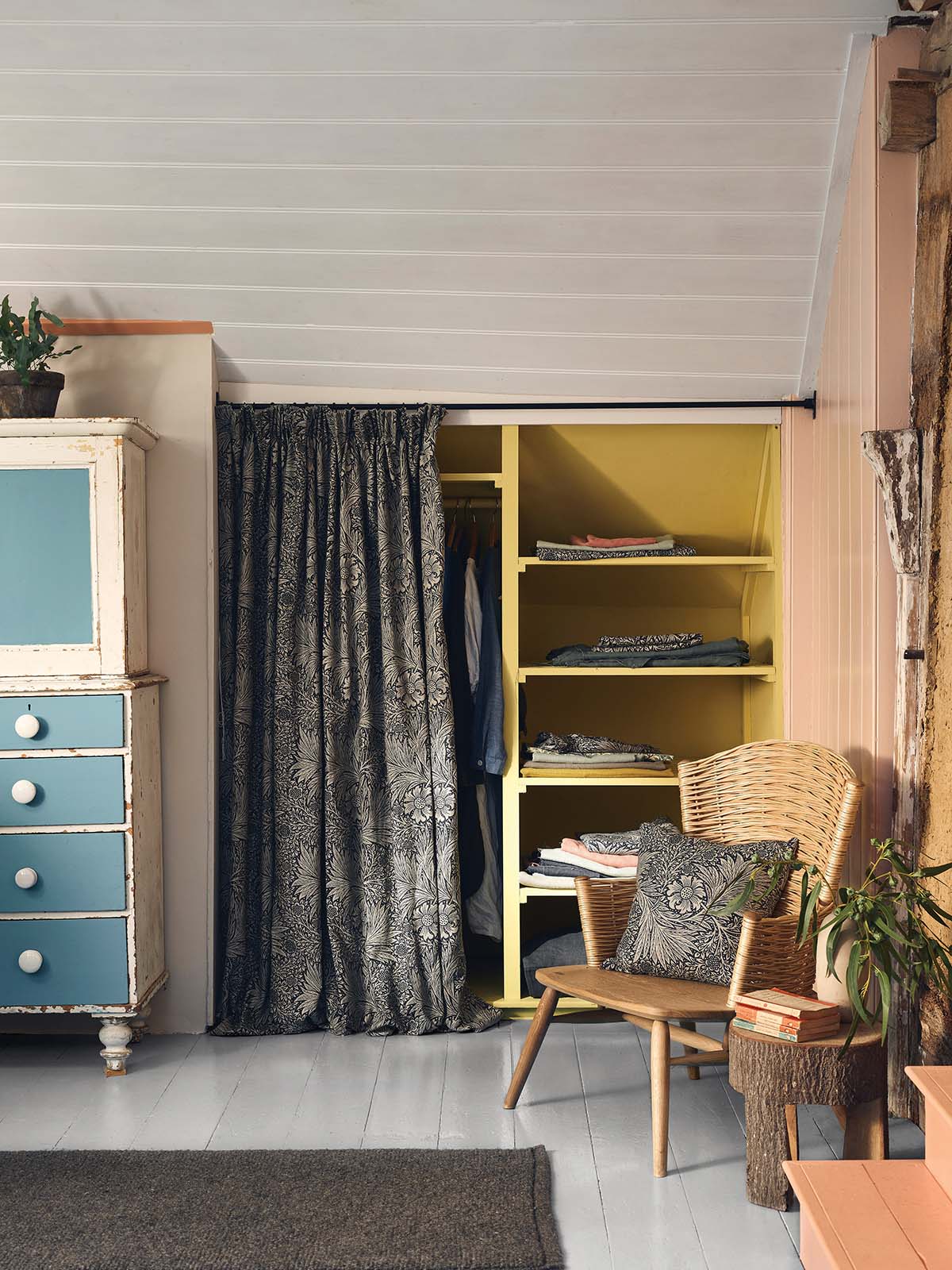yellow shelves, blue cabinets and pink curtains in a craft room